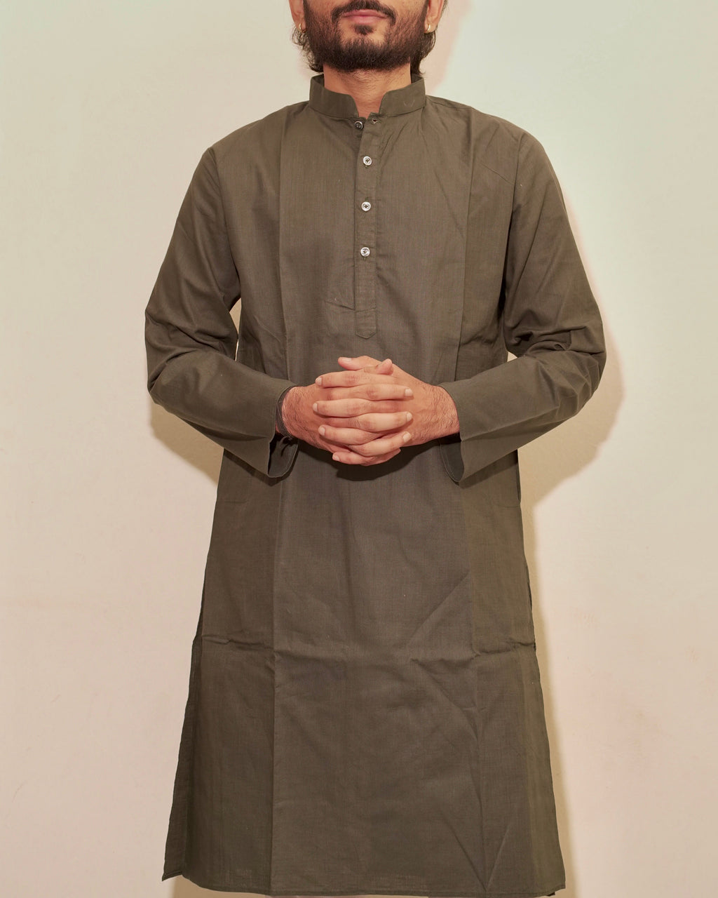 A man wearing a long-sleeved Bottle green kurta with a mandarin collar and buttoned chest, standing against a plain off-white background.